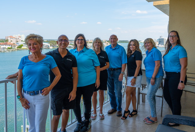Clearwater property management services are provided by iTrip Clearwater, owned by Kevin Jenkins. Kevin's team is pictured here on a balcony with the ocean in the background